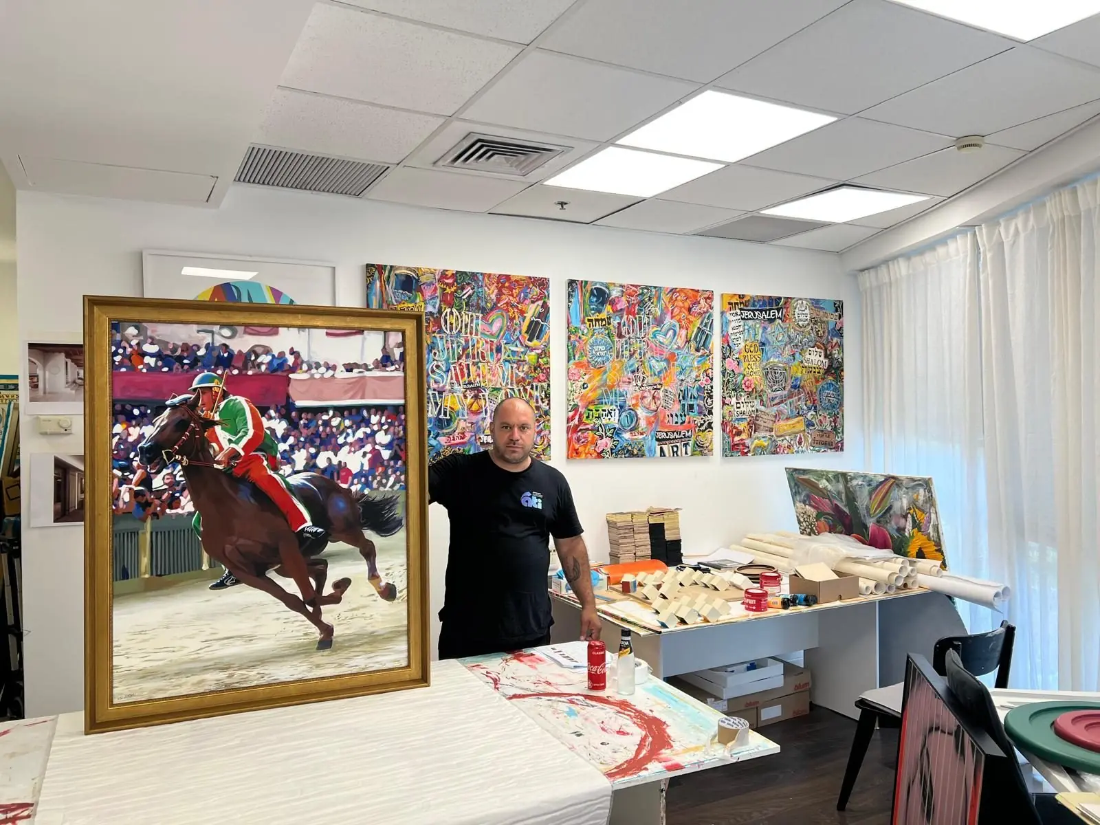 One of our team standing beside a painting of a horse and rider, ready to ship