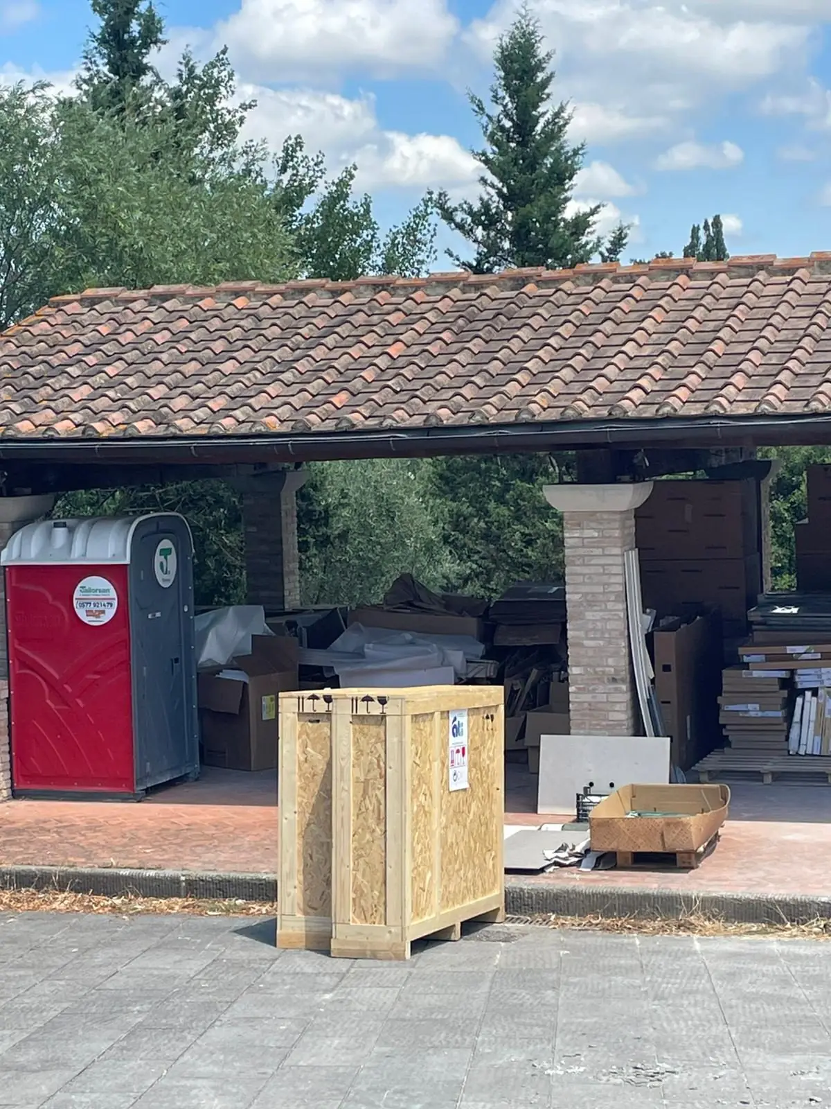 A wooden crate waiting under a tiled pavilion
